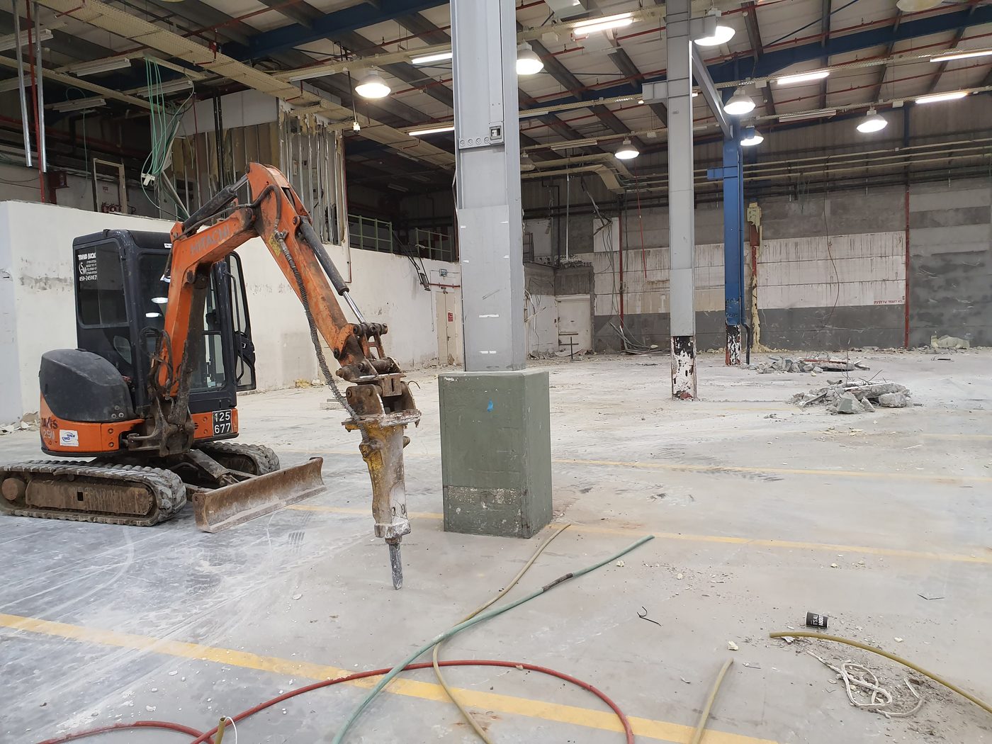 מחפרון עומד בשטח תעשייה פתוח אחרי הריסת המחיצות